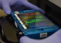 In this picture taken on August 22, 2018, a technician places an array containing DNA information in a scanner at GeseDNA Technology in Beijing. - China's DNA sequencing market was worth about 7.2 billion yuan (1.05 billion USD) last year and is forecast to grow to 18.3 billion yuan in 2022, according to estimates by Beijing-based CCID Consulting. (Photo by GREG BAKER / AFP) / To go with China-genetics-demographics-DNA, Feature by Danni Zhu and Elizabeth Law