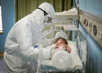 FILE PHOTO: A medical staff attends to a baby with novel coronavirus at the Wuhan Children’s Hospital, in Wuhan, the epicentre of the novel coronavirus outbreak, in Hubei province, China March 6, 2020. China Daily/via REUTERS/File Photo ATTENTION EDITORS - THIS IMAGE WAS PROVIDED BY A THIRD PARTY. CHINA OUT. SEARCH "1ST ANNIVERSARY OF THE WUHAN LOCKDOWN" FOR THE PHOTOS.