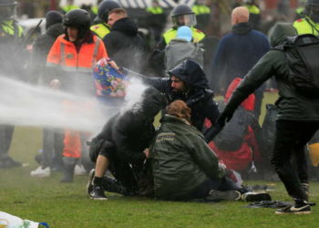 Police uses a water canon during a protest against restrictions put in place to curb the spread of the coronavirus disease (COVID-19), in Amsterdam, Netherlands January 24, 2021. REUTERS/Eva Plevier