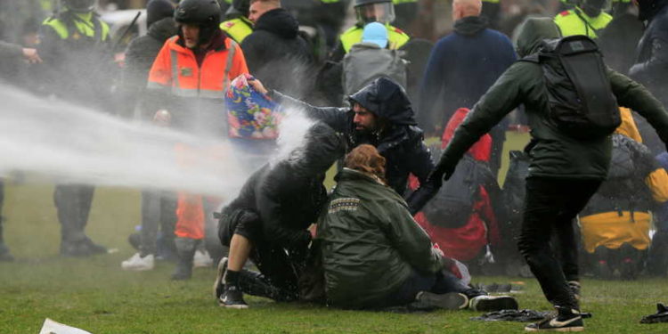 Police uses a water canon during a protest against restrictions put in place to curb the spread of the coronavirus disease (COVID-19), in Amsterdam, Netherlands January 24, 2021. REUTERS/Eva Plevier