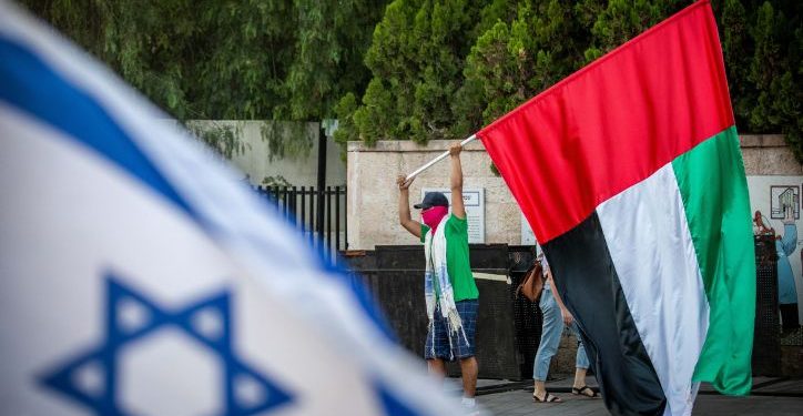 A man waves a giant United Arab Emirates flag outside the Prime Minister's official residence in Jerusalem on August 19, 2020. Photo by Yonatan Sindel/Flash90 *** Local Caption *** ????? ?????????
???
???
???????
?????
??? ??????
?????