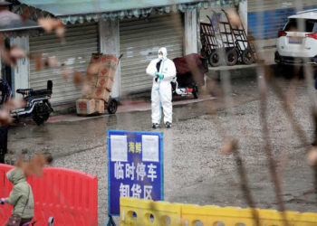 FILE PHOTO: A worker in a protective suit is seen at the closed seafood market in Wuhan, Hubei province, China January 10, 2020. Picture taken January 10, 2020. REUTERS/Stringer/File Photo/File Photo