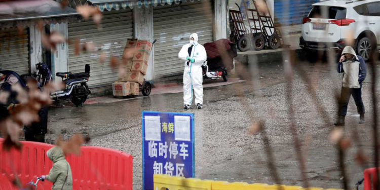 FILE PHOTO: A worker in a protective suit is seen at the closed seafood market in Wuhan, Hubei province, China January 10, 2020. Picture taken January 10, 2020. REUTERS/Stringer/File Photo/File Photo