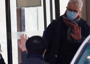 Dominic Dwyer, a member of the World Health Organisation (WHO) team tasked with investigating the origins of the coronavirus disease (COVID-19), waves as they leave their quarantine hotel in Wuhan, Hubei province, China January 28, 2021. REUTERS/Thomas Peter