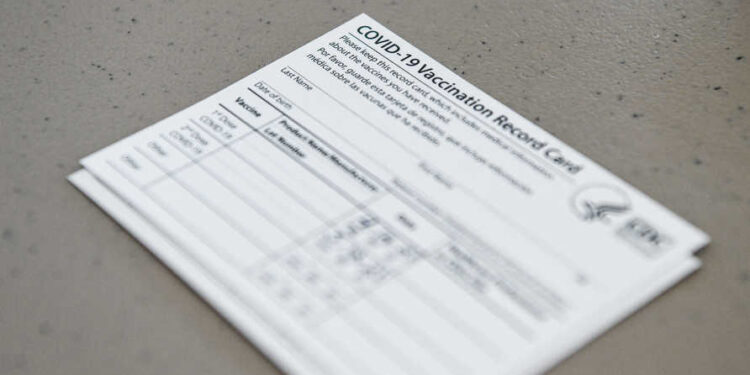 A Covid-19 vaccine record card is seen at Florida Memorial University Vaccination Site in Miami Gardens, Florida on April 14, 2021. - Florida Division of Emergency Management has opened a new permanent vaccination site at Florida Memorial University. The walk-up site will administer 200 doses of Moderna vaccine per day to any Florida resident over the age of 18. (Photo by CHANDAN KHANNA / AFP)