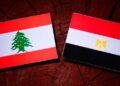 Lebanese flag with Egyptian flag on a tree stump isolated