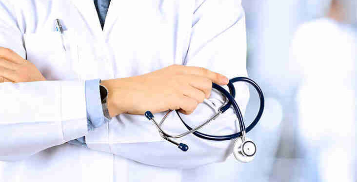 Portrait an unknown male doctor holding a stethoscope behind