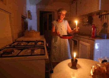 A woman holds a lighted candle after power cuts at her house in Beirut, Lebanon.