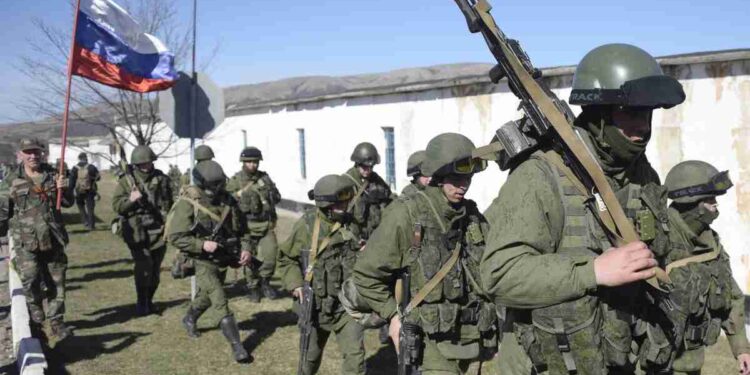 A man with a Russian flag greets armed men in military fatigues blocking access to a Ukrainian border guards base not far from the village of Perevalne near Simferopol on March 3, 2014.  About 1,000 armed men surrounded the base of the 36th detached brigade of the Ukrainian Navy's coastal guards since yesterday in a tense standoff in the flashpoint Crimea peninsula. Russian troops and military planes were flowing into Crimea today in violation of accords between the two countries, Ukrainian border guards said. AFP PHOTO / ALEXANDER NEMENOV        (Photo credit should read ALEXANDER NEMENOV/AFP/Getty Images)